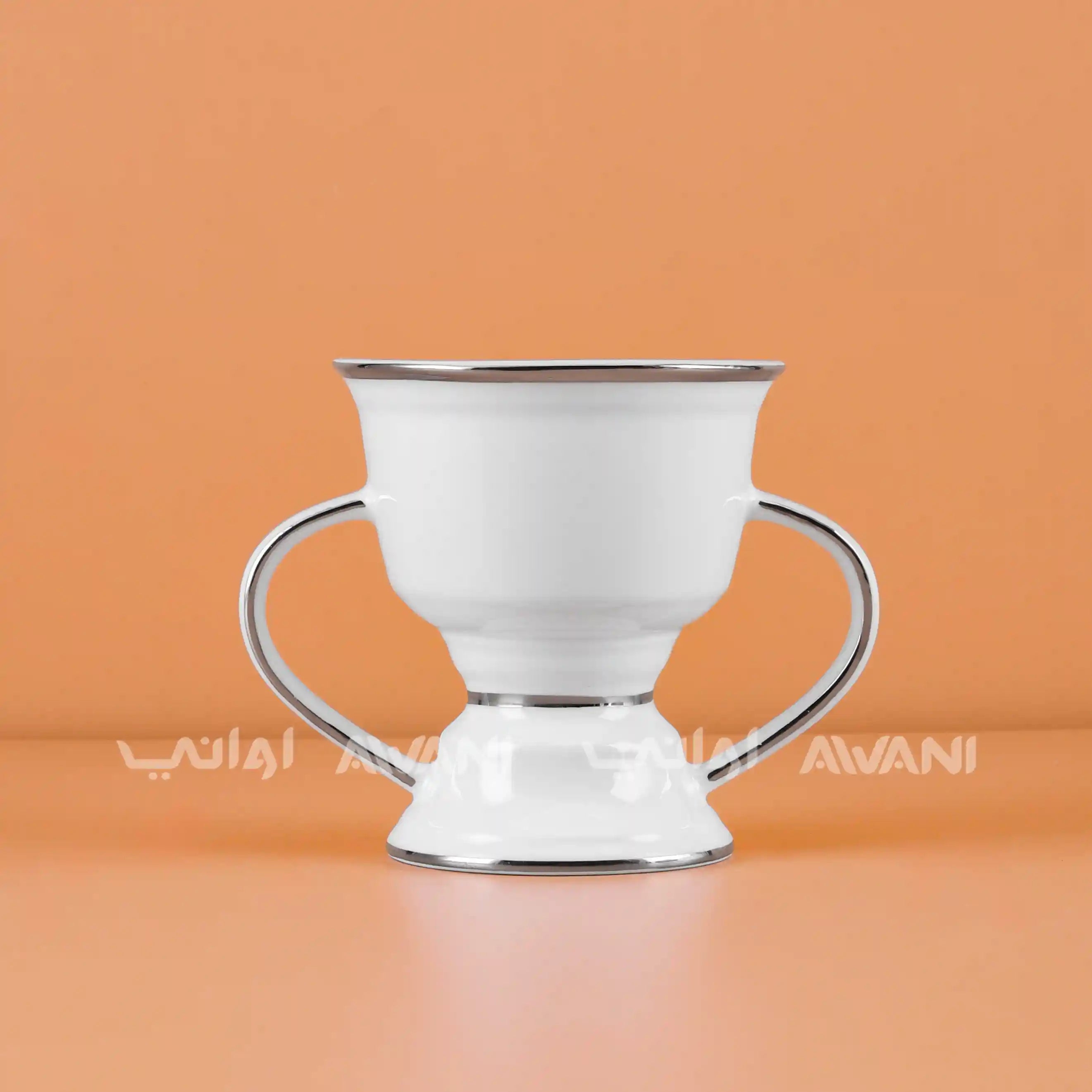 White ceramic cup with handles on an orange background, featuring the brand 'Avani'.